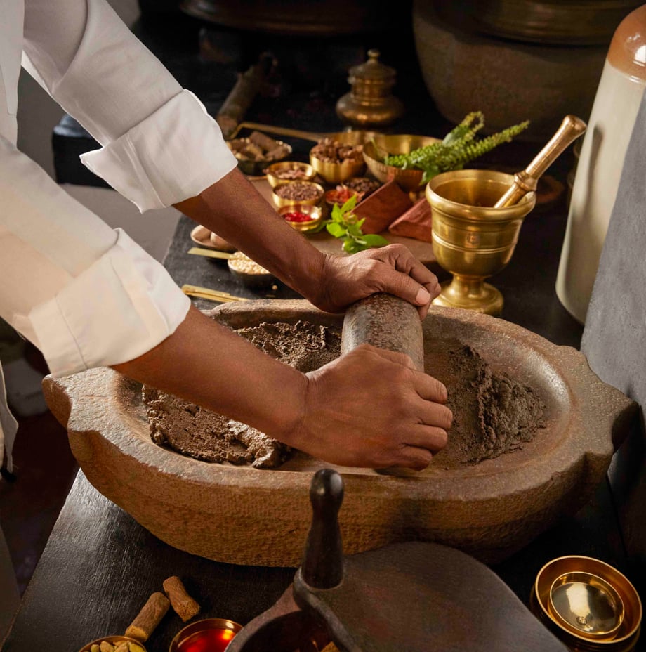 Image of a man blending ingredients into a paste.png